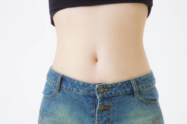 Beyaz arka planda kot giyen kadın göbeği