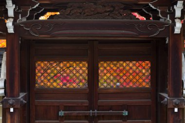 Geleneksel ahşap kapı kafes panelleri ve sonbahar yeşillik arka planı