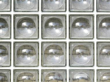İçerideki ışığı yansıtan kare cam blokların tekrarlanan deseni