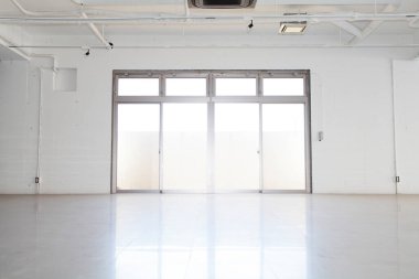Modern binanın içi, beyaz duvarlı boş bir alan.        