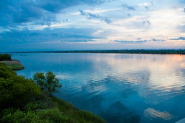 Bulutlu gökyüzü ve gölde gün batımı
