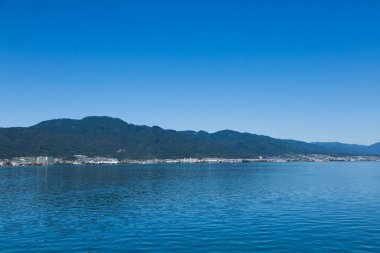 Deniz suyunun güzel manzarası, manzaralı tepeler ve kıyı kasabası      
