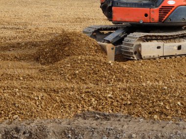 Buldozer inşaat sahasında çakıl taşıyor.