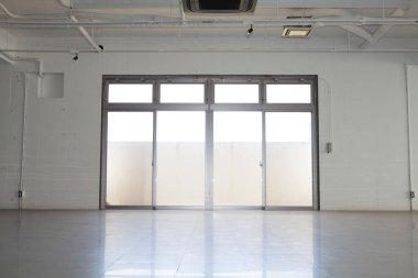 Modern binanın içi, beyaz duvarlı boş bir alan.        