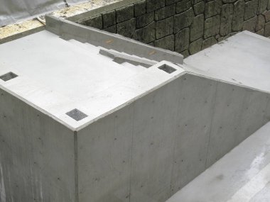 Keskin açıları ve pürüzsüz dış yüzeyleri olan taze beton yapı.