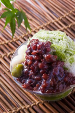 Arka planda haşlanmış azuki fasulyesi ve erikli Matcha buzu, yakın plan.