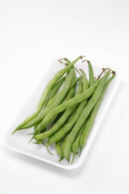 Beyaz arkaplanda yeşil bezelyeler.