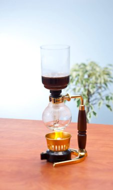 Tahta masada demlenen kahve makinesini çek.