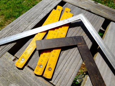 Dışarıdaki ahşap masa yüzeyinde dinlenen ölçü aletleri.