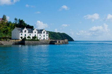 Sakin mavi okyanus sularına bakan beyaz kıyı evleri