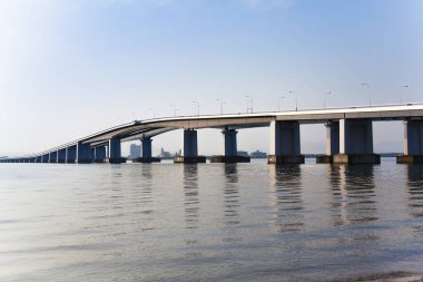 Nehir üzerinde mavi gökyüzü ve arka planda binalar olan köprü