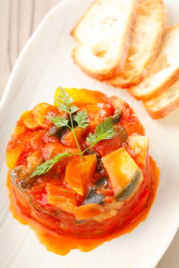 Bir tabak sebze yahnisi ve dilimlenmiş ekmek. 