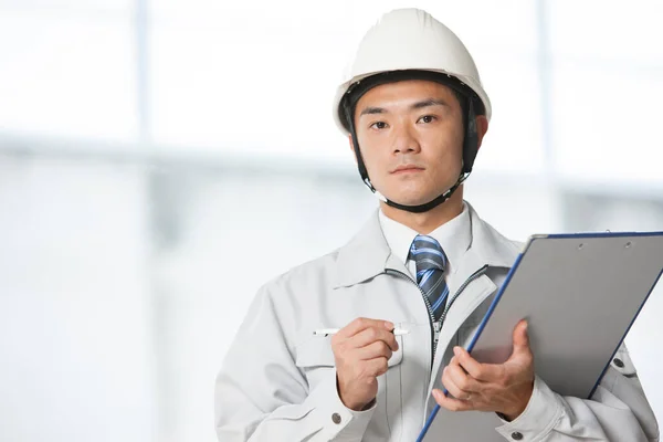 handsome asian engineer in uniform at building construction