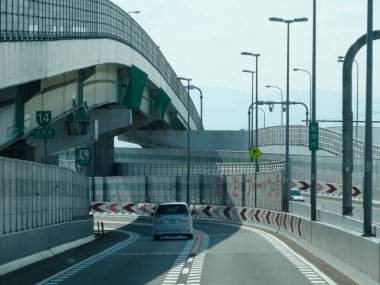 Engellerle çevrili modern yüksek otoyol boyunca araba sürüyor.