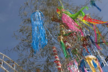 Renkli kurdelelerle süslenmiş ağaç dalları, tatil dekorasyonunun gündüz manzarası. 