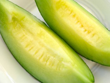 Beyaz bir tabakta dilimlenmiş taze organik kavun..