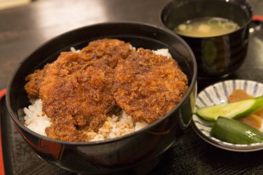 Pirinç buğulama üzerinde gevrek domuz pirzolası dinleniyor.