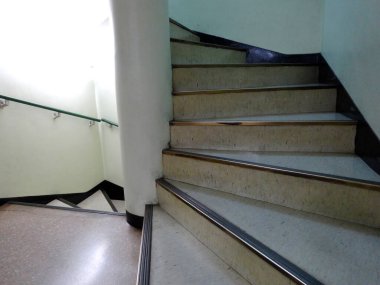 Güneş ışığı, kapalı alandaki boş merdiven boşluğuna akıyor.