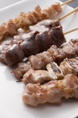 Beyaz tabakta şişler olan leziz ızgara et manzarası       