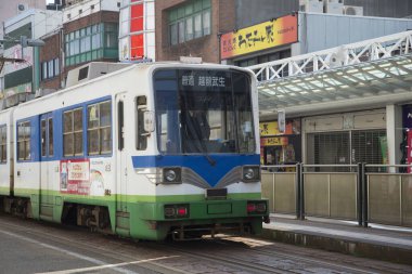 Modern şehir Japonya 'da gündüz tramvayı sokak sokak geziyor.