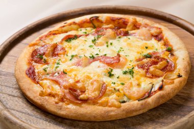 Tahtada pişmiş lezzetli pizzanın yakın plan görüntüsü.