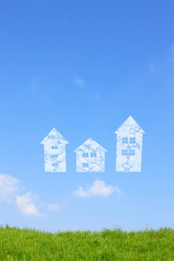 Mavi gökyüzü arka planında yeşil çimenler ve beyaz evler                        
