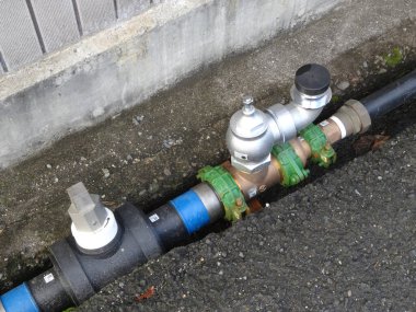 Metal su vanası dışarıdaki siyah boruya bağlı.