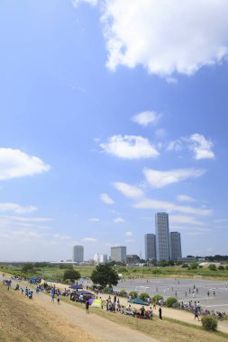 Futako Tamagawa Rise Tower ve Residence, Tokyo, Japonya 'ya karşı sahada futbol oynayan insanlar