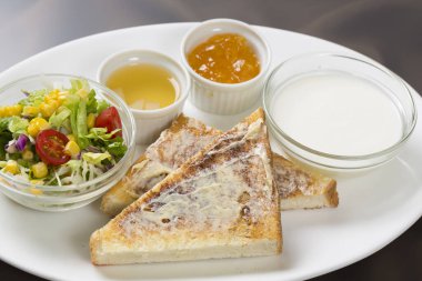 Salata ve sütün yanında tereyağlı tost dilimleri
