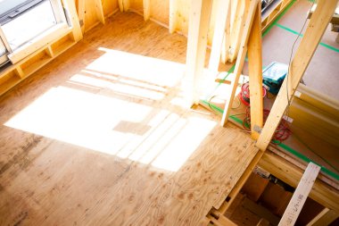 Güneş ışığı bitmemiş ahşap inşaat alanını aydınlatıyor.