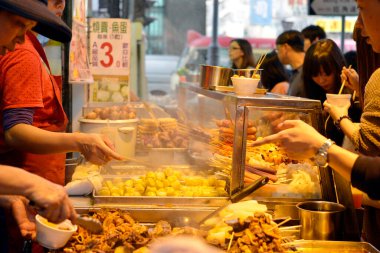 İnsanlar Hong Kong 'daki sokak pazarından alışveriş yapıyor.