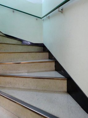 Bej basamaklı kıvrımlı merdiven, modern iç aydınlatma parmaklıkları.