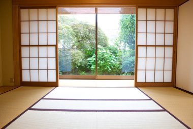 Sunlit geleneksel Japon tatami odası. Bahçeye bakan Shoji kapıları var.