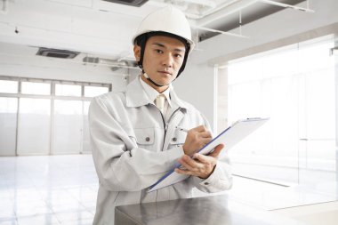 İnşaat alanında üniformalı yakışıklı bir mimarın portresi.