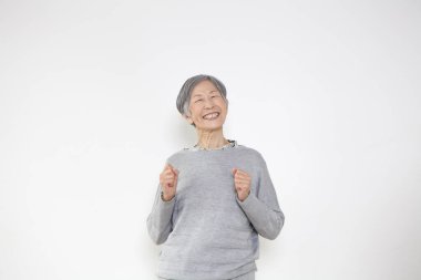 Stüdyoda gri kıyafetler giyen mutlu bir son sınıf öğrencisi. 