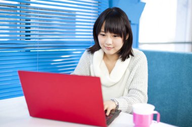 Bilgisayarlı güzel Asyalı kadının yakın plan portresi.