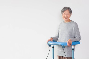 gülümseyen yaşlı Asyalı kadın ve Walker