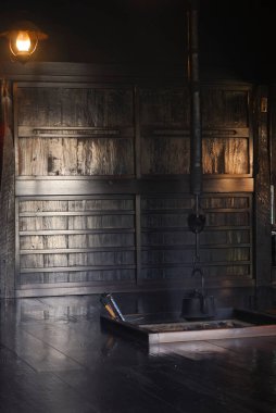 Ahşap duvarlar ve tek bir ışığın olduğu karanlık oda.