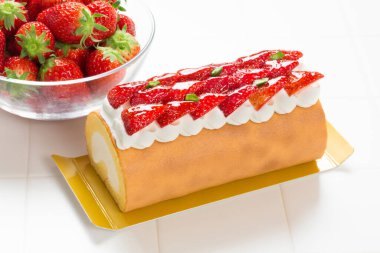 Üstünde çilek ve krema olan kek.