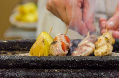 Sebze ve etle ızgara yapan kişi.