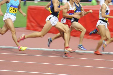 Bulanık erkek sporcu gündüz stadyumda koşuyor. 