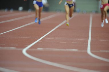 Bulanık erkek sporcu gündüz stadyumda koşuyor. 