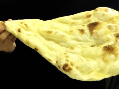 Eliniz taze pişmiş naan ekmeği tutarken