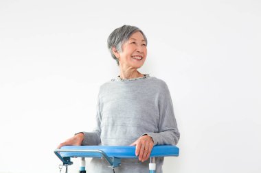 gülümseyen yaşlı Asyalı kadın ve Walker