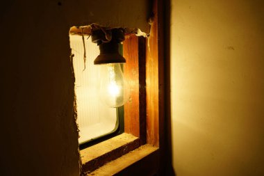 Duvardaki delikte parlayan ampul