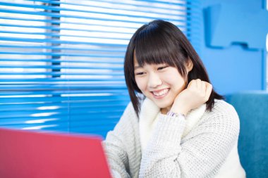 Bilgisayarlı güzel Asyalı kadının yakın plan portresi.