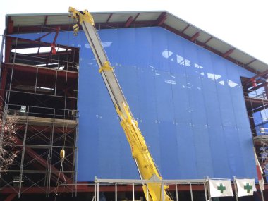 Vinç inşaat alanında ve gökyüzünde çalışıyor.