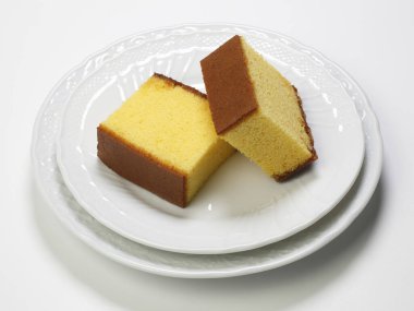 Tabaklarda duran iki altın sünger keki.