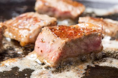  Biftekler kızartma tavasında pişiriliyor.