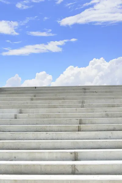 concrete stairs and blue sky with fluffy clouds